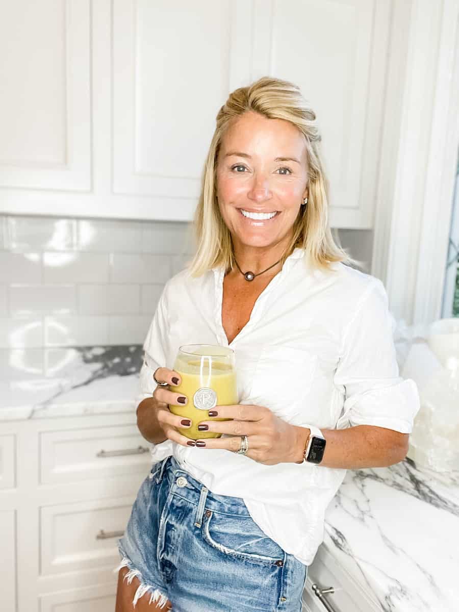 Menopause health coach Deanna Pizitz standing in a kitchen drinking Pumpkin Smoothie
